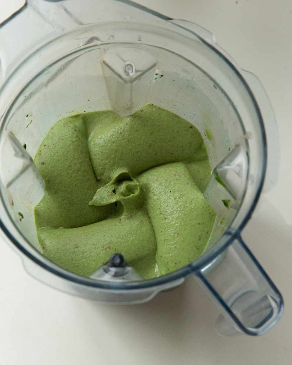 a thick blended choc chip mint smoothie in a vitamix jug